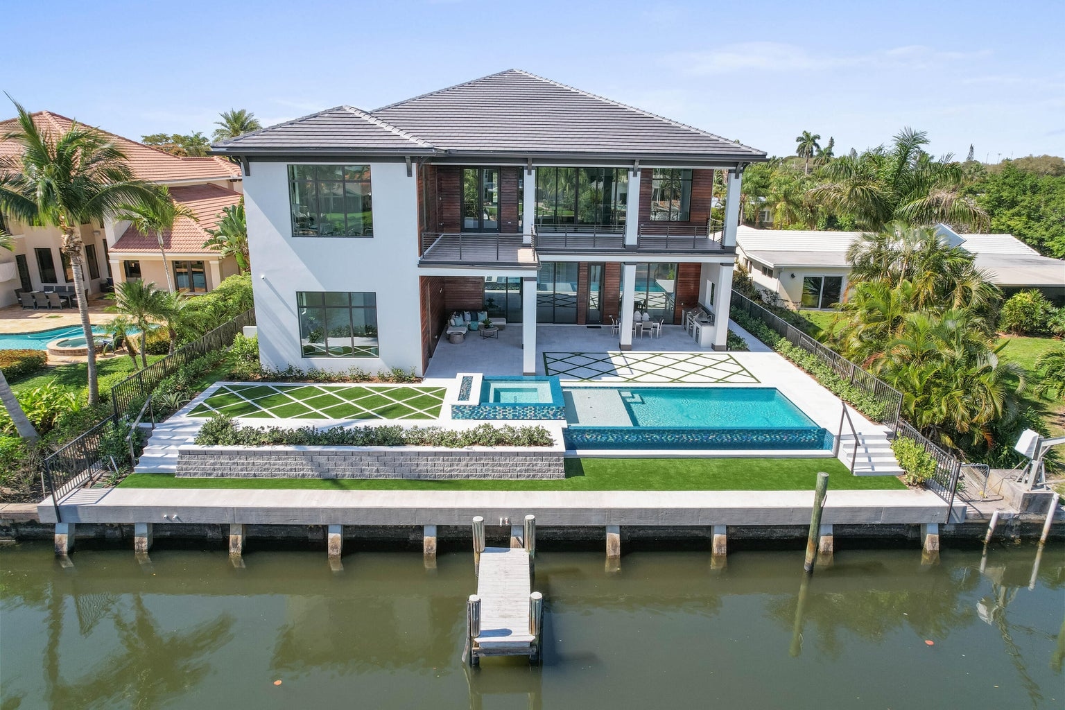 736 Lagoon Drive aerial view from the waterway — pool, dock, rear elevation