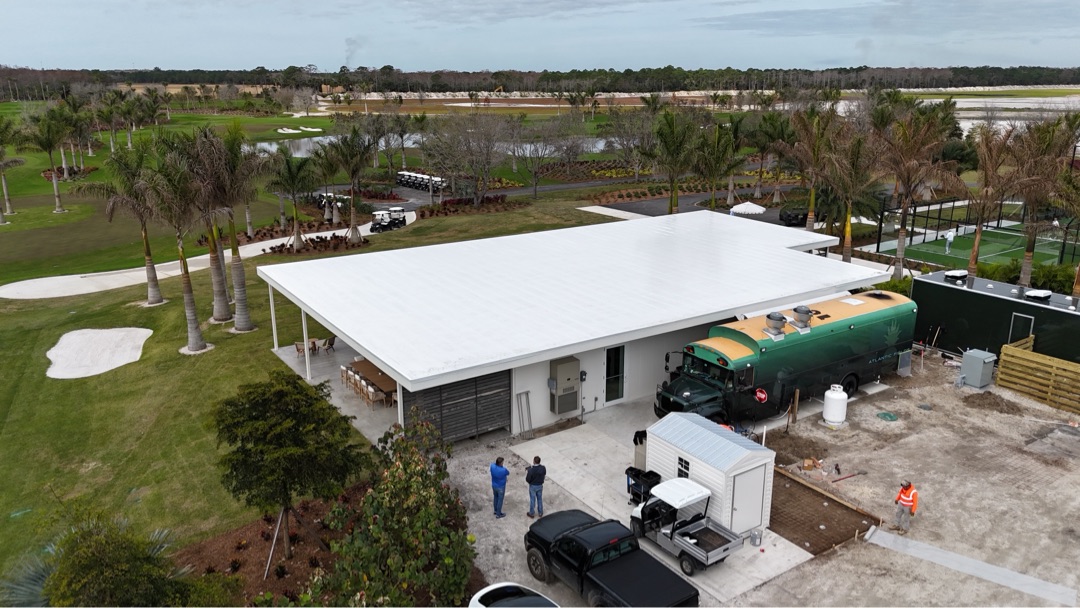 Atlantic Fields Sales Center back of house during construction &mdash; service block, food-truck staging, racquet club beyond
