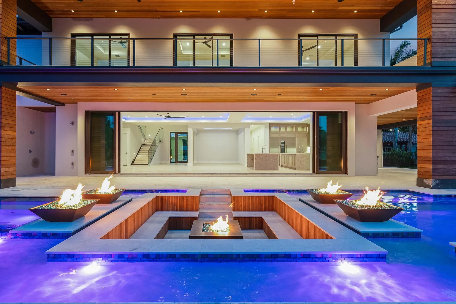 Pool area with fire features and floor-to-ceiling glass