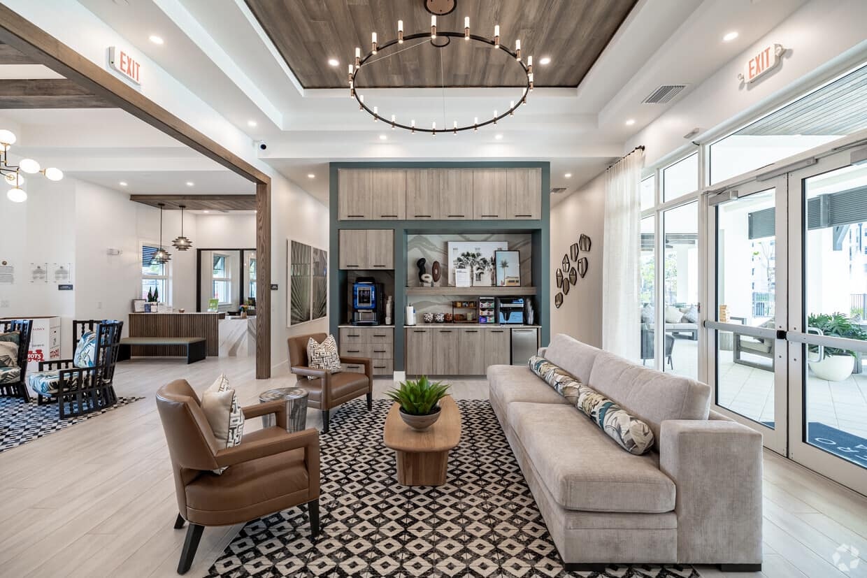 Estero Vista clubhouse interior — glass storefront entry doors opening to the exterior amenities