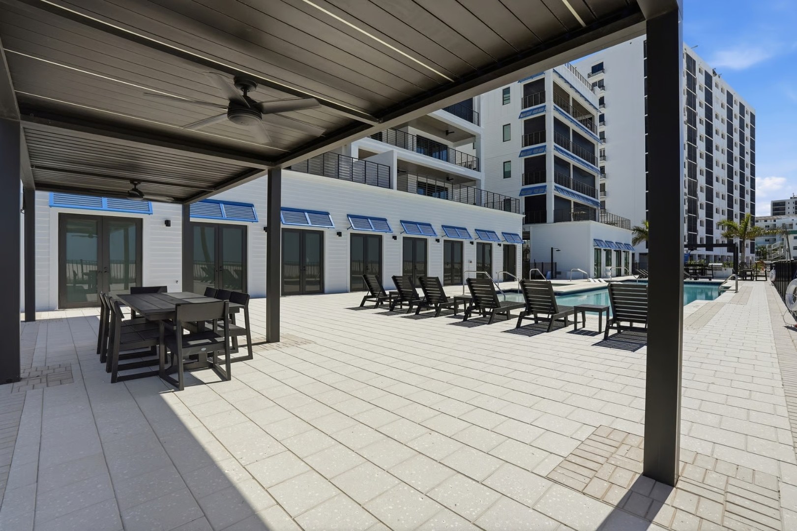 Pool-level amenity deck with cabana and storefront glazing