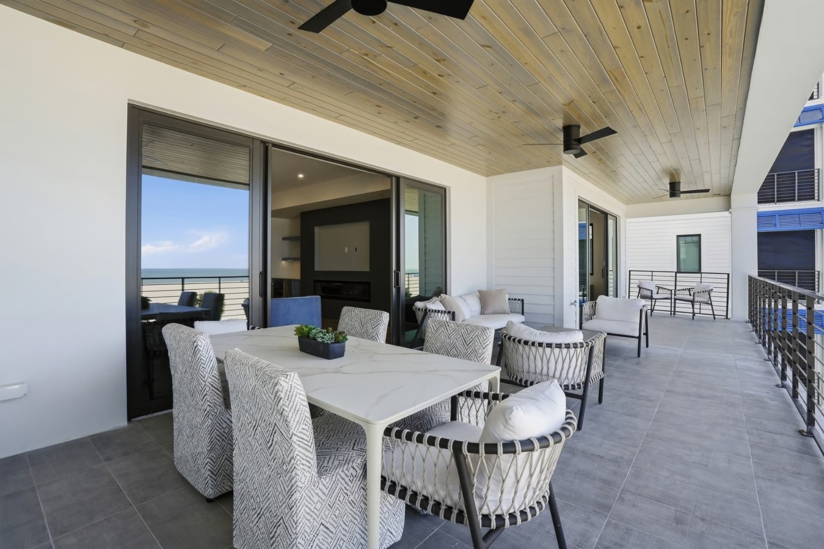 Covered balcony dining with sliders open to the Gulf