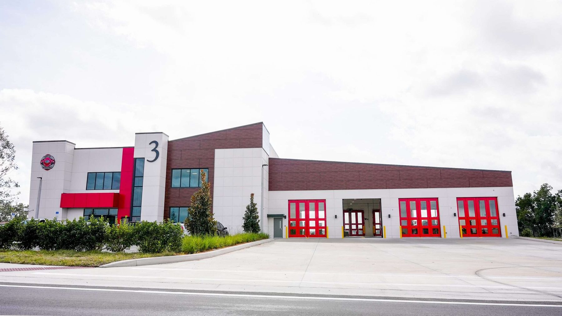 Full exterior of the Haines City Public Safety Complex showing apparatus bay, two-story office block, and primary entry