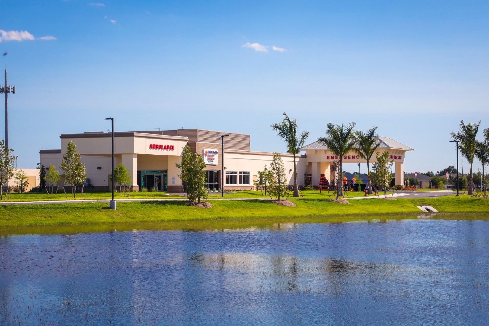HCA Florida Cape Coral Emergency reflected in pond — full building view