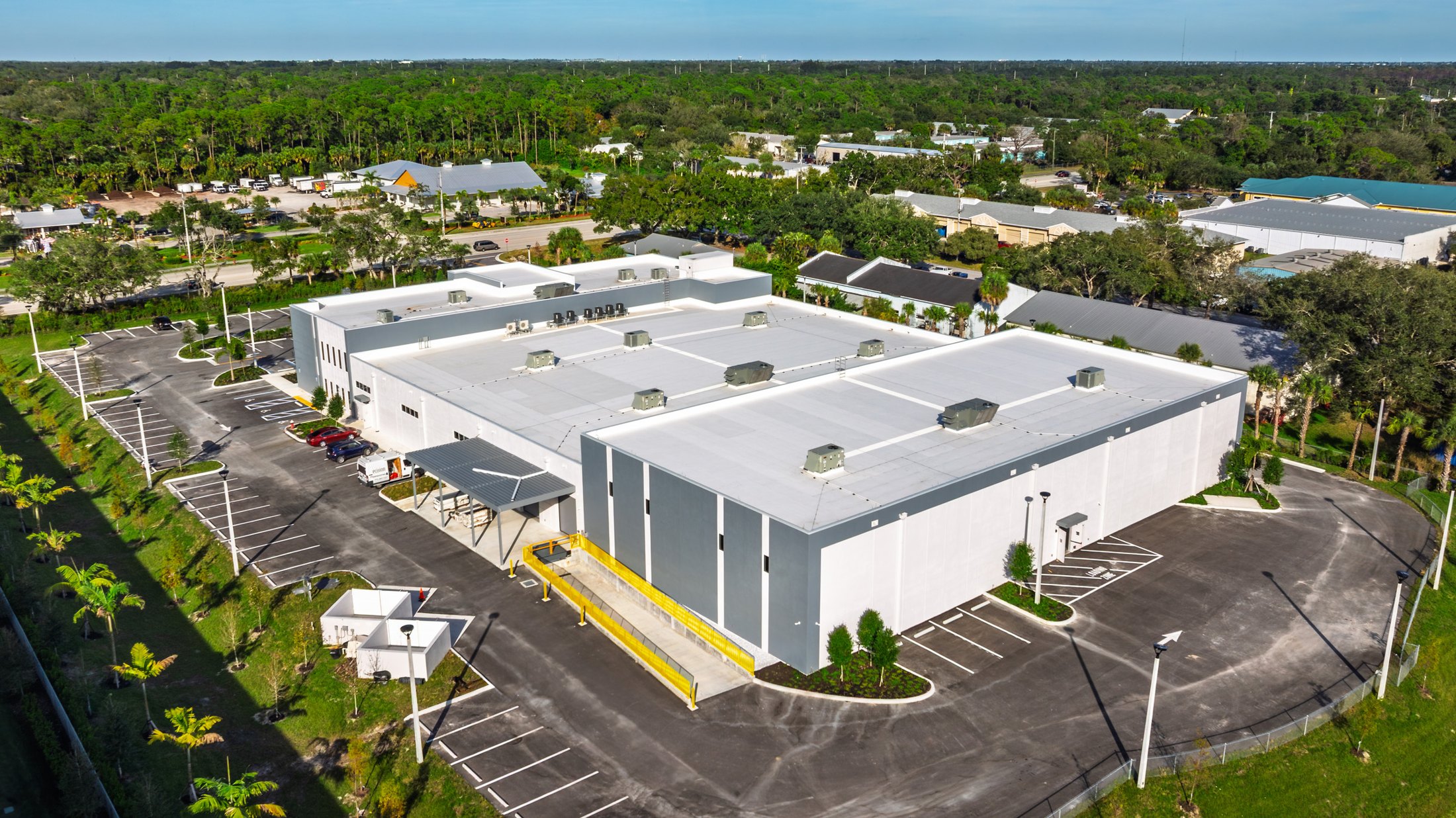KLUS Lighting Vero Beach — aerial from the back corner showing the warehouse roof line, the surrounding industrial neighborhood, and the punched window facade