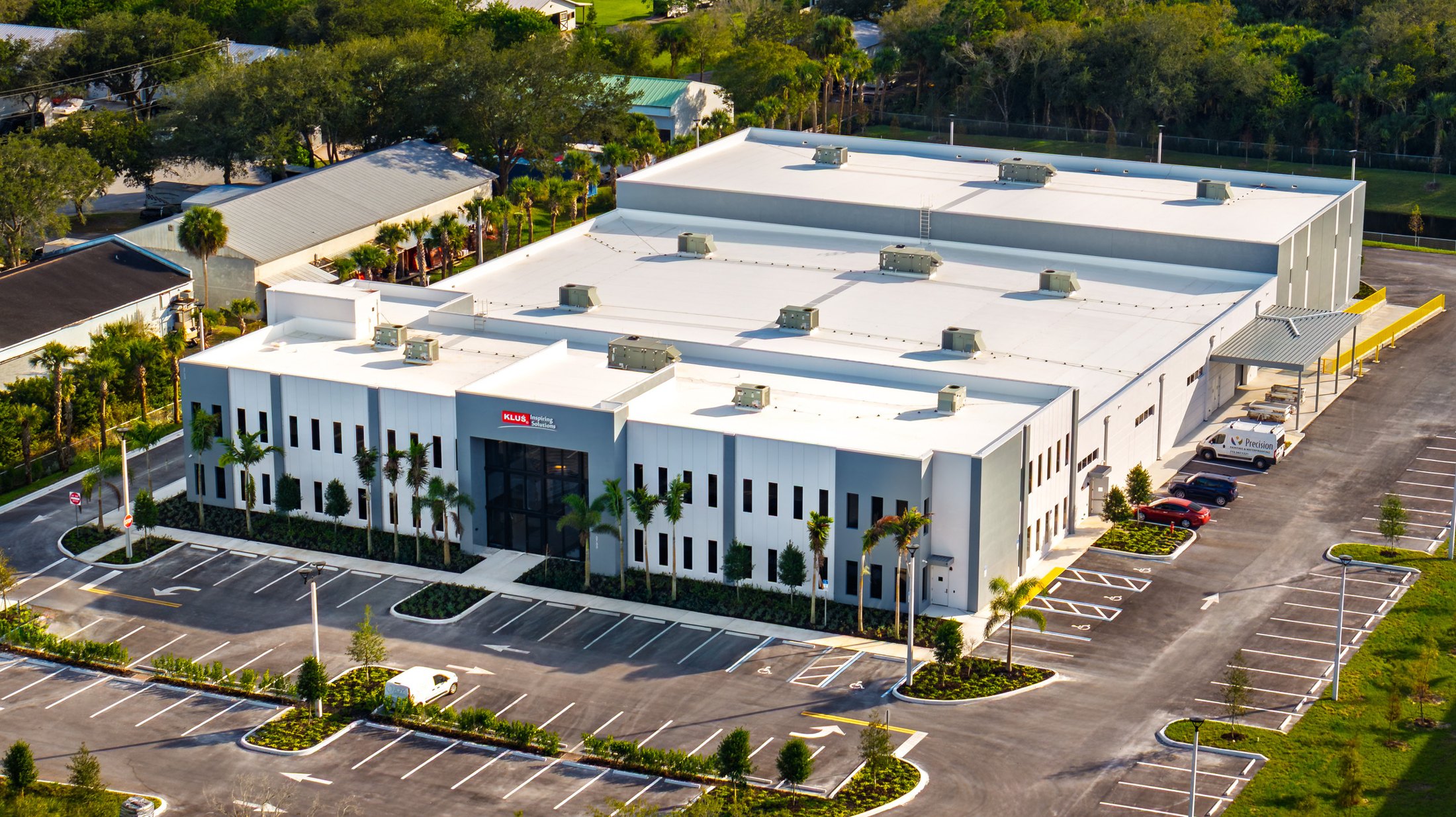 KLUS Lighting Vero Beach — aerial of the front and side elevations together, showing the relationship between the entry tower and the larger warehouse mass
