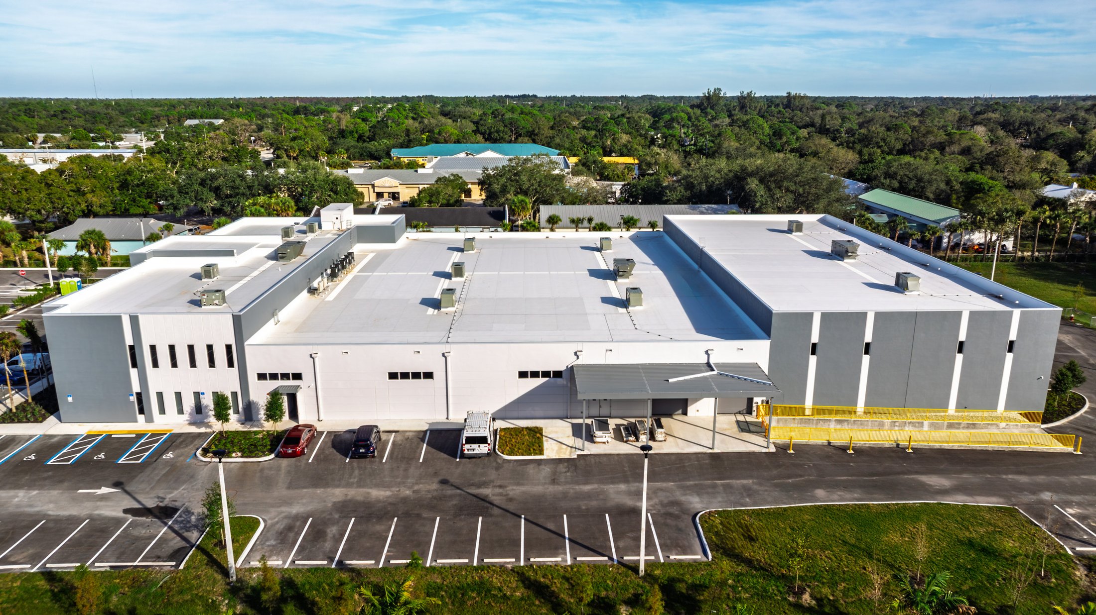 KLUS Lighting Vero Beach — aerial side context view showing the side elevation with punched windows and the loading area, full Indian River County setting