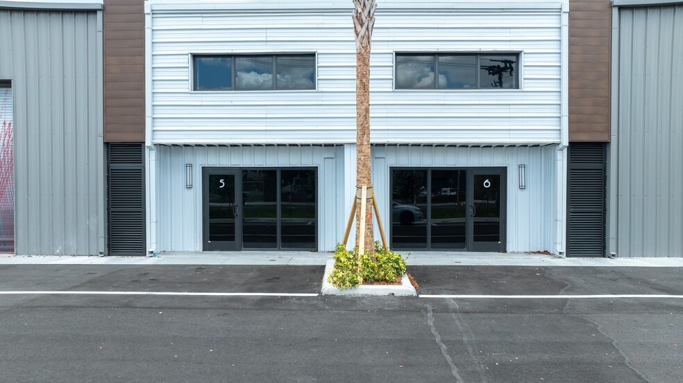 Medley Business Park — close-up of CGIC dark-framed storefront bays 5 and 6 with entry doors and upper windows